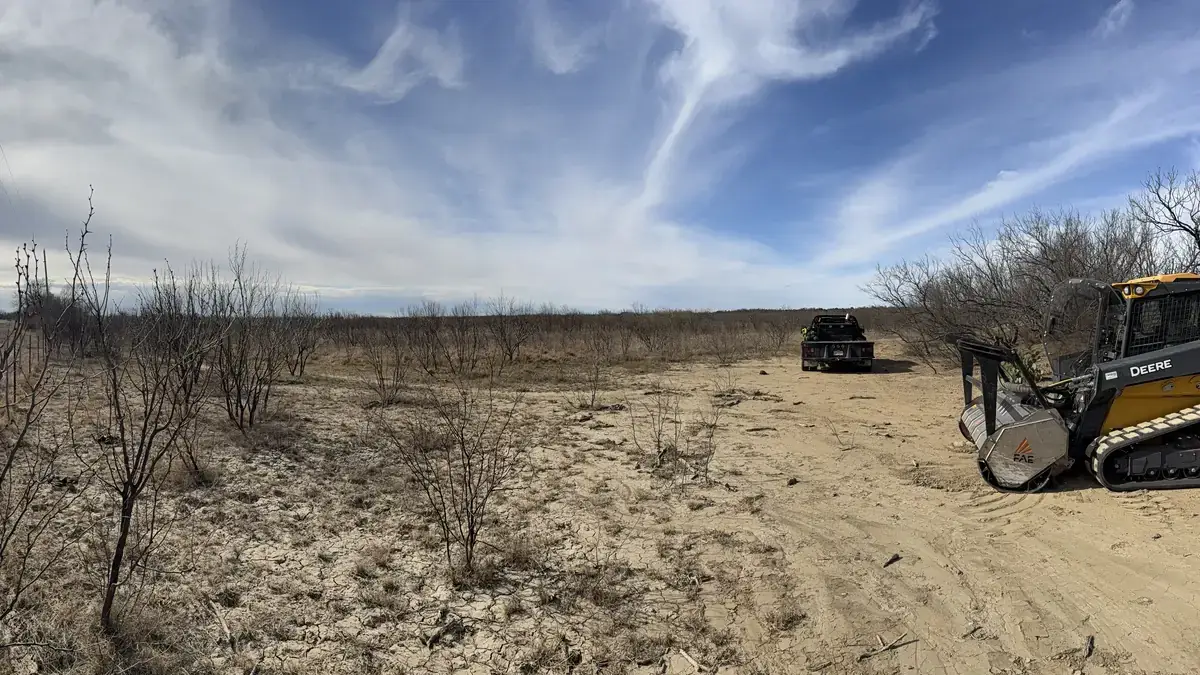 Land-clearing equipment working through dormant brush on a Central Texas property